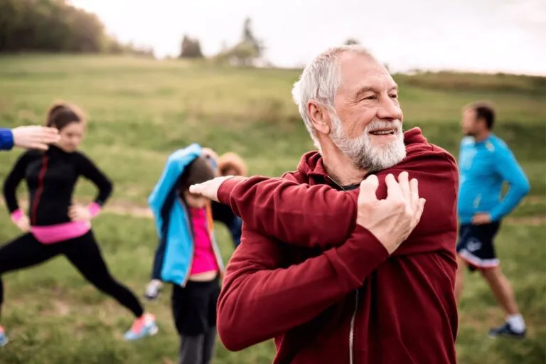 Un homme âgé qui effectue un étirement de l'épaule pour avoir une articulation en bonne santé physique.
